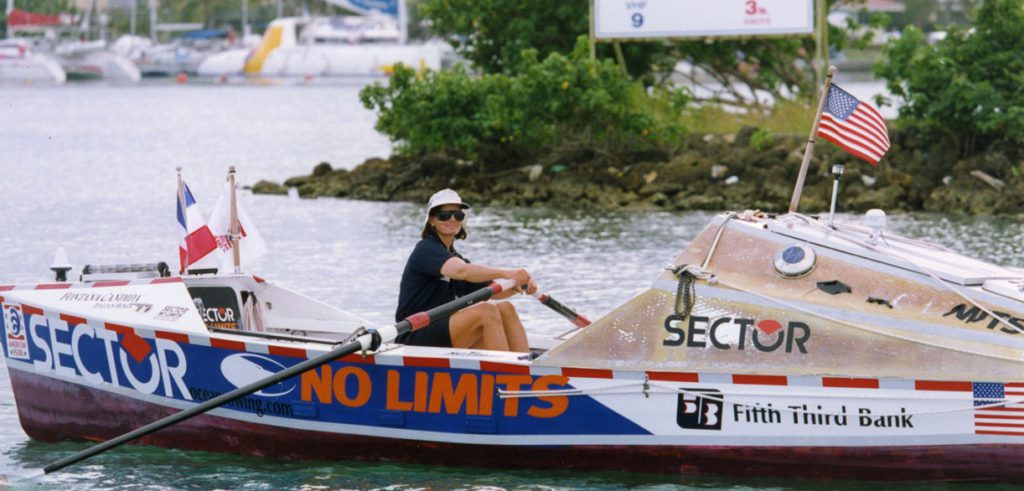 Tori Murden McClure in Guadeloupe sitting in American Pearl boat she rowed across Atlantic.