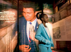 Young girl explores Muhammad Ali Center exhibit.