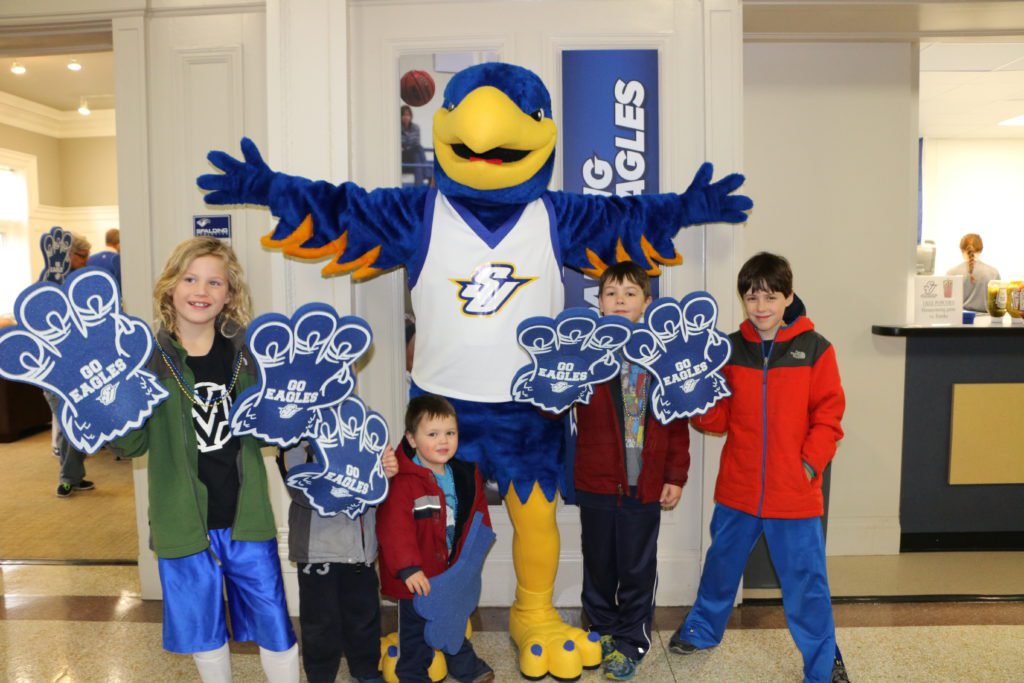 Spalding mascot poses for picture with young kids wearing foam eagle claws
