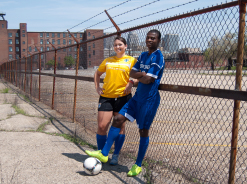 Athletes pose along chainlink fence at abandoned Ninth Street property