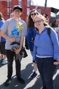 Three students smile outside during the Spalding rat race parade