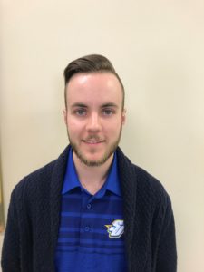 Head shot of Alumni Relations Manager Liam Clemen, wearing blue Spalding shirt and a dark sweater