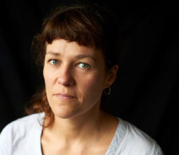 Head shot of author Rachel Seiffert, in front of dark background