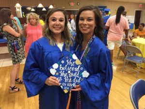 Shelby Keeling and Celine Seger, wearing blue graduation gowns