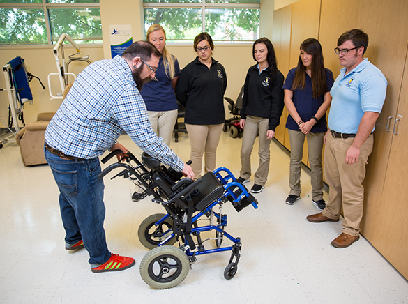 Dr. Skuller demonstrates wheelchair for OT students