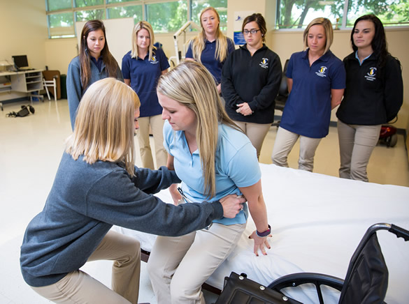 OT Student and professor demonstrate moving from wheelchair to bed