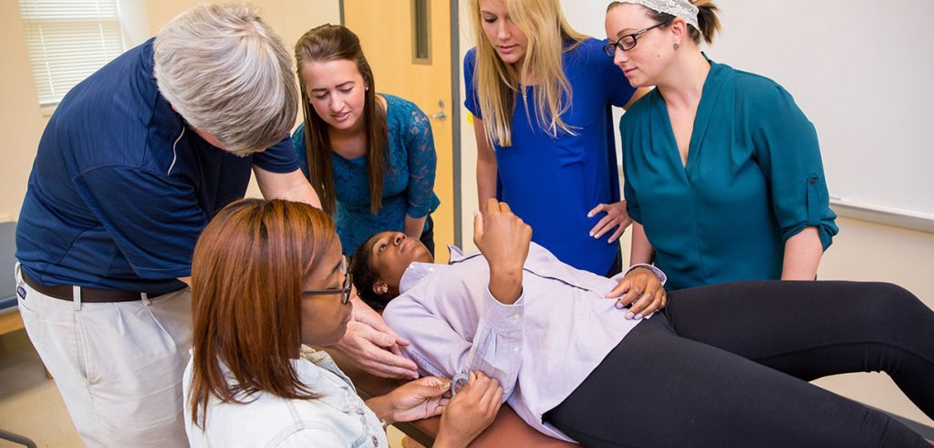 Group of OT students learning hands-on from professor