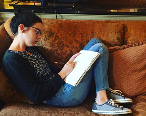 Ashley-Alliano-Writing-on-Brown-Couch