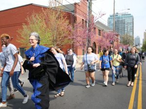 President Tori Murden McClure and a group of students walk down S. Fourth St. during the rat race parade