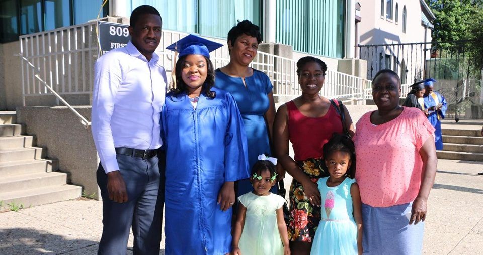 Spalding student Witchina Liberal, wearing blue cap and gown, poses with family and friends