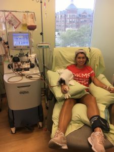 Spalding student Miranda Wray sitting chair with arm connected to a machine that is extracting stem cells she was donating