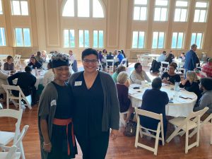 Spalding's Chandra Irvin and Janelle Rae standing in front of a room of people seated around tables