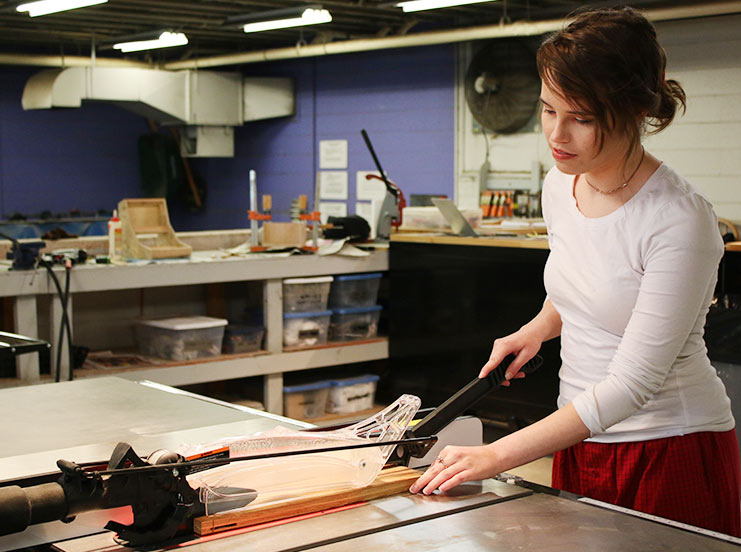 Art student using cutting table in Spalding's Maker Space on campus.