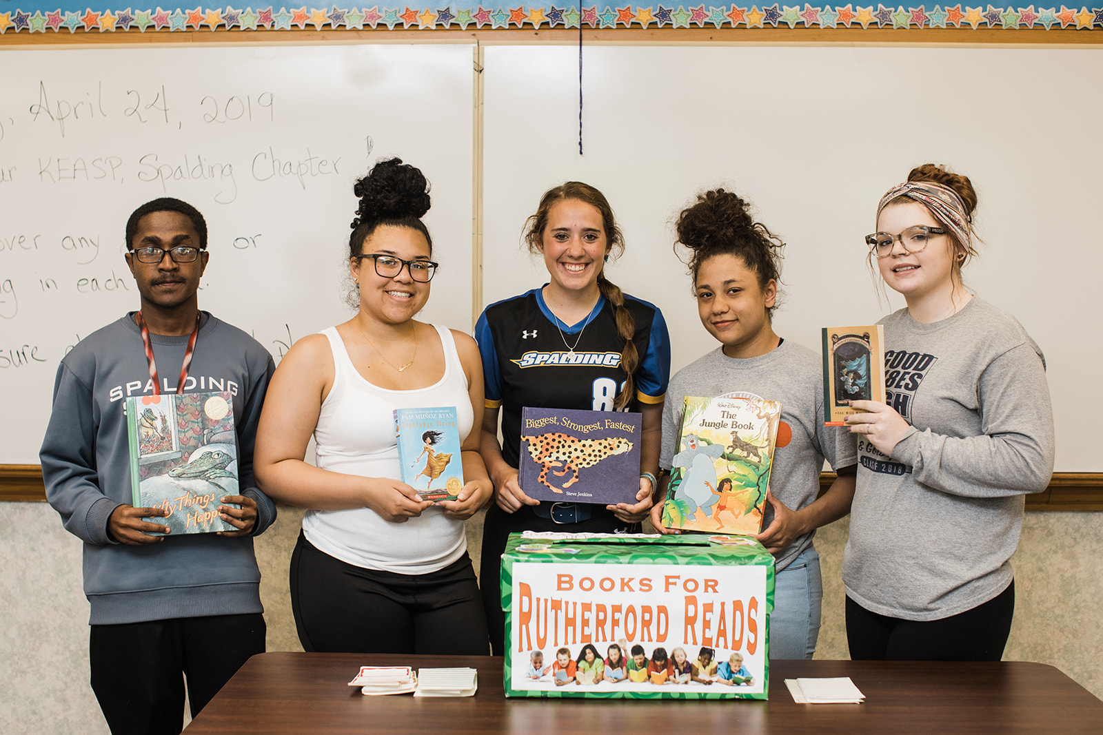 Spalding student volunteers hold donated books