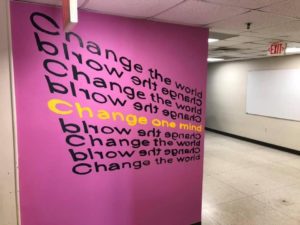 A mural that read "Change the World, Change One Mind" in the Spalding art studios