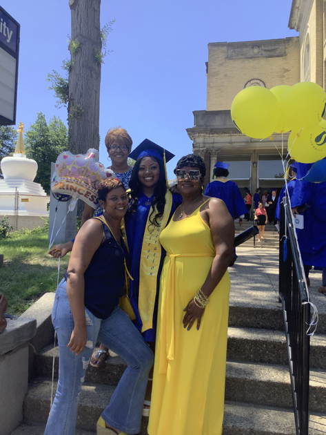 Spalding grad with family on steps of Columbia Gym side entrance