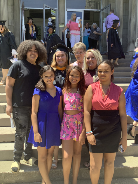Spalding grad with family on steps outside Columbia Gym