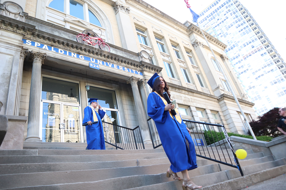 2 Spalding grads on stairs outside Columbia Gym