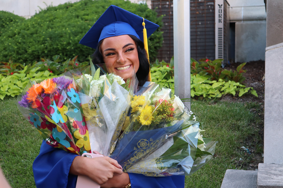 Spalding grad with flowers after ceremony