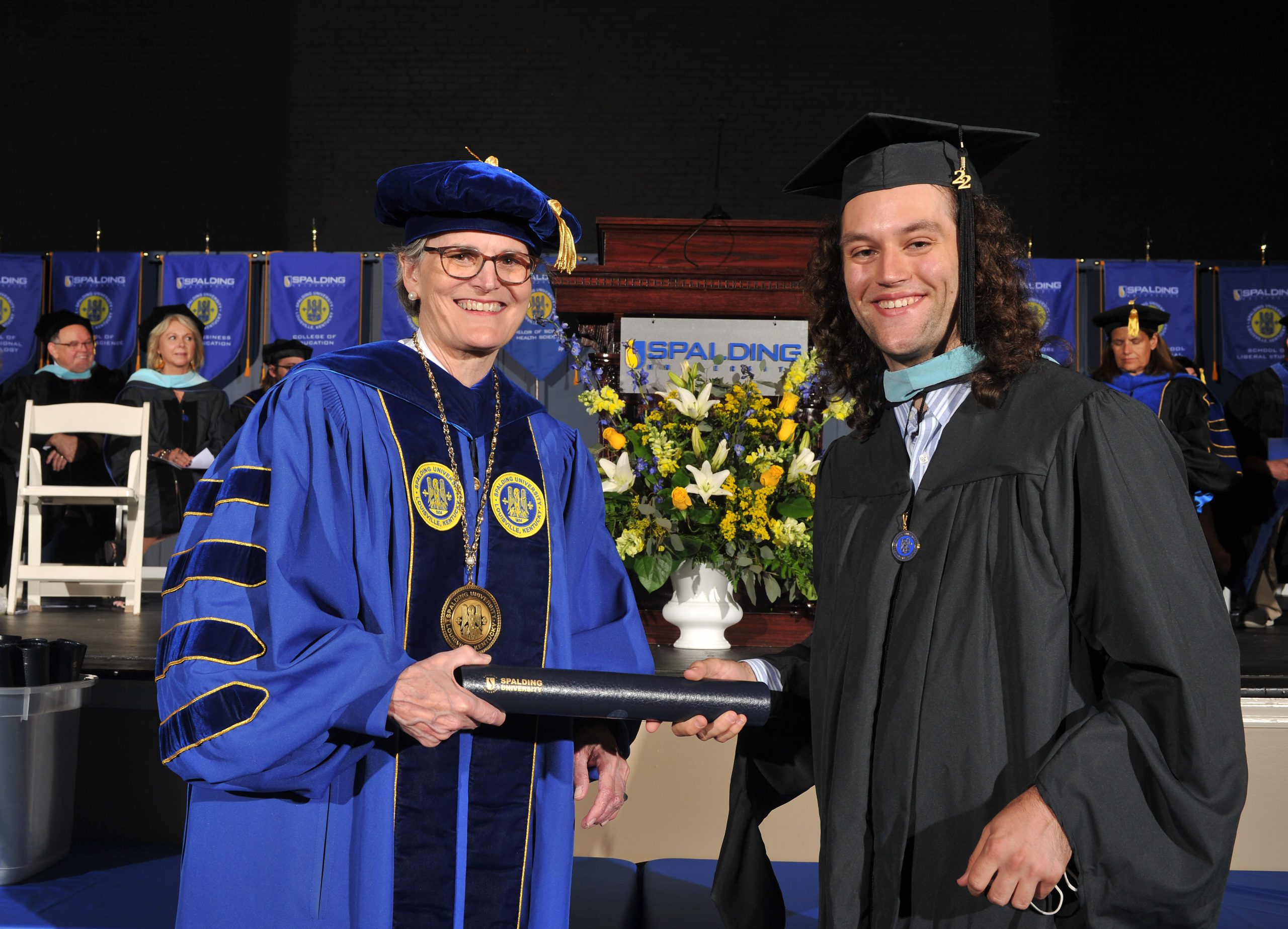 Baxter receiving his degree from President Tori Murden McClure