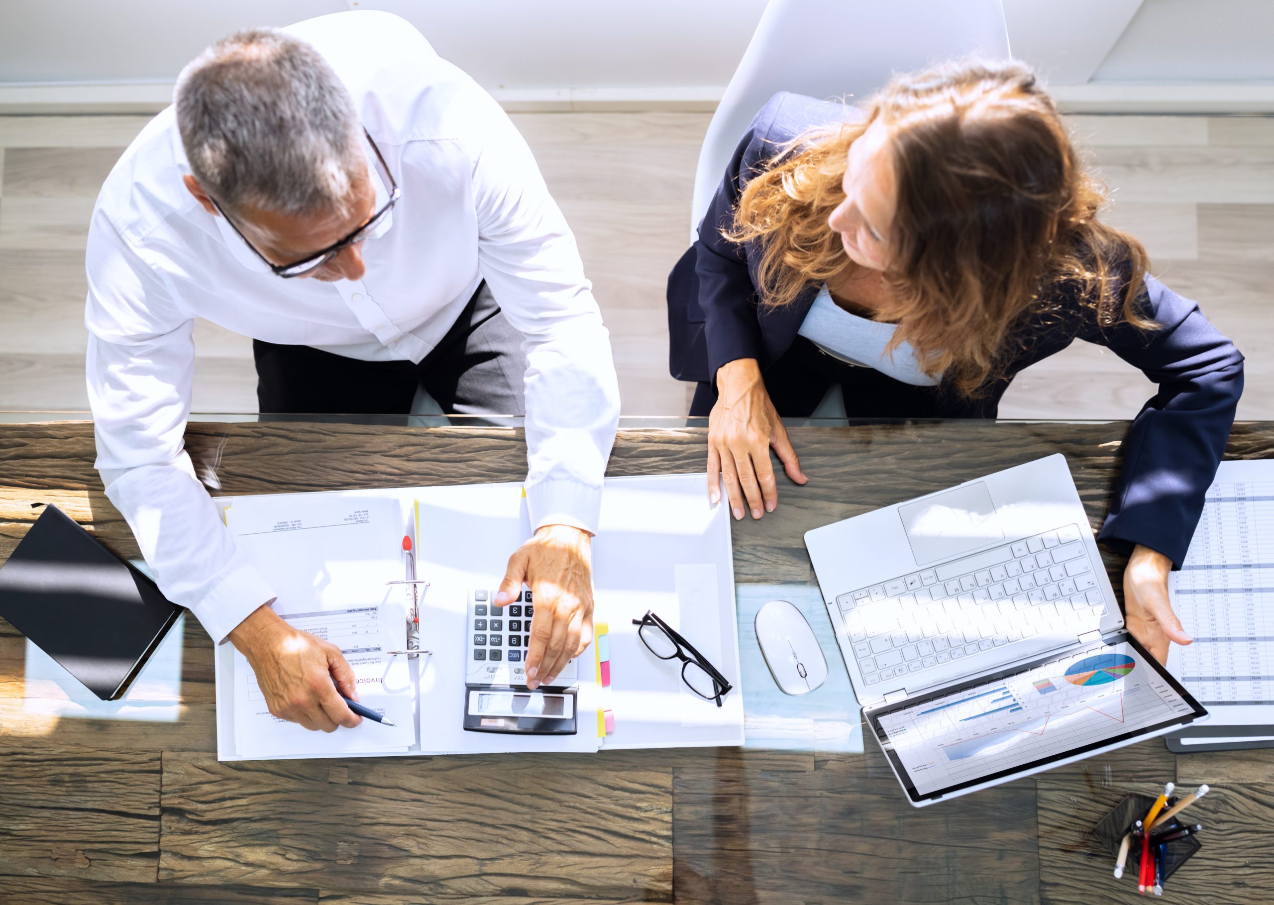 Manager And Senior Accountant Using Laptop In Office