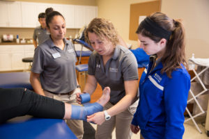 Spalding athletic training students learning to wrap an ankle