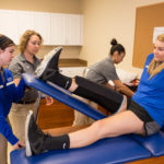 Spalding athletic training students working with Spalding athlete