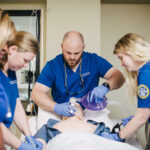 Spalding nursing students practice providing air for patient on dummy