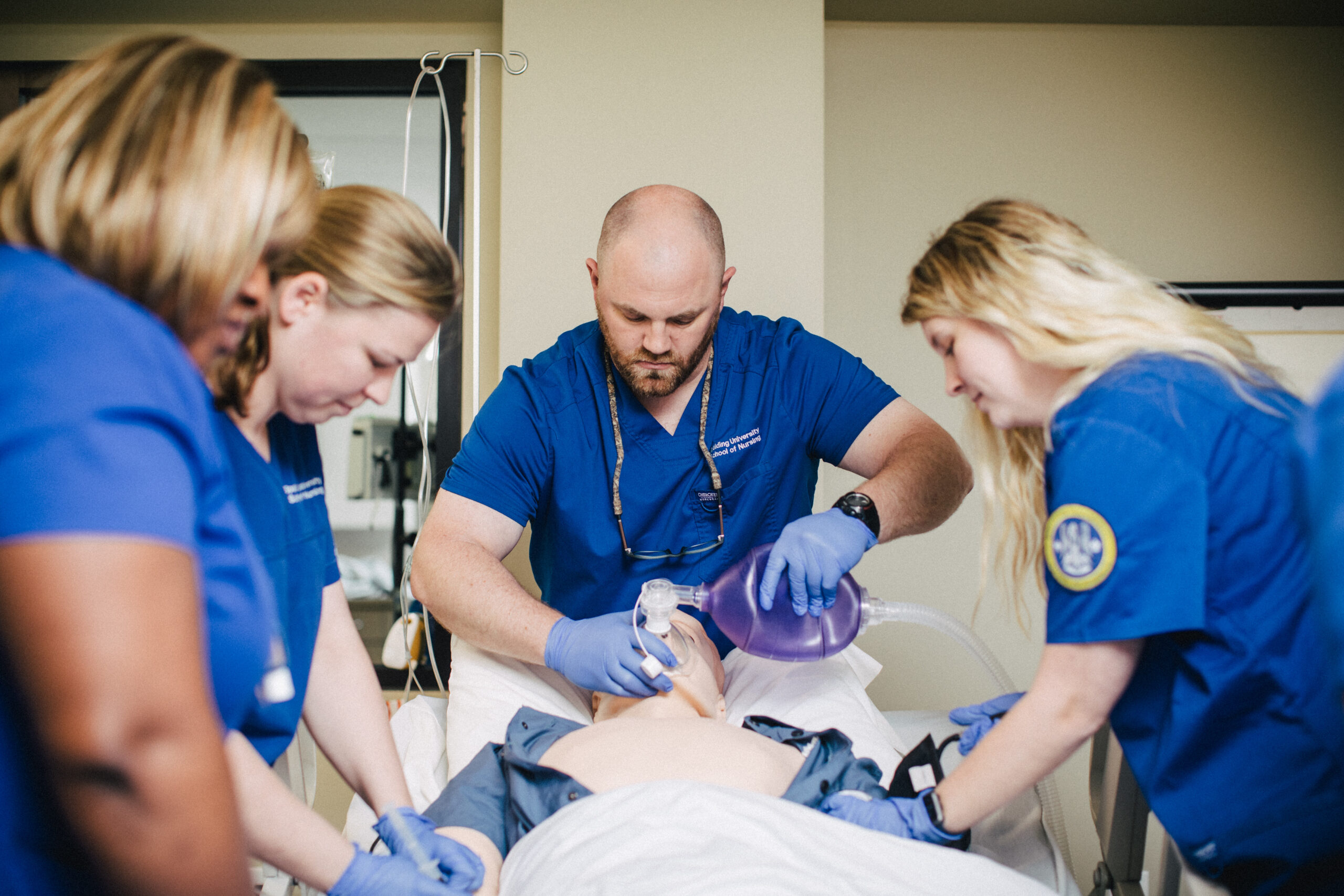 Spalding nursing students practice providing air for patient on dummy