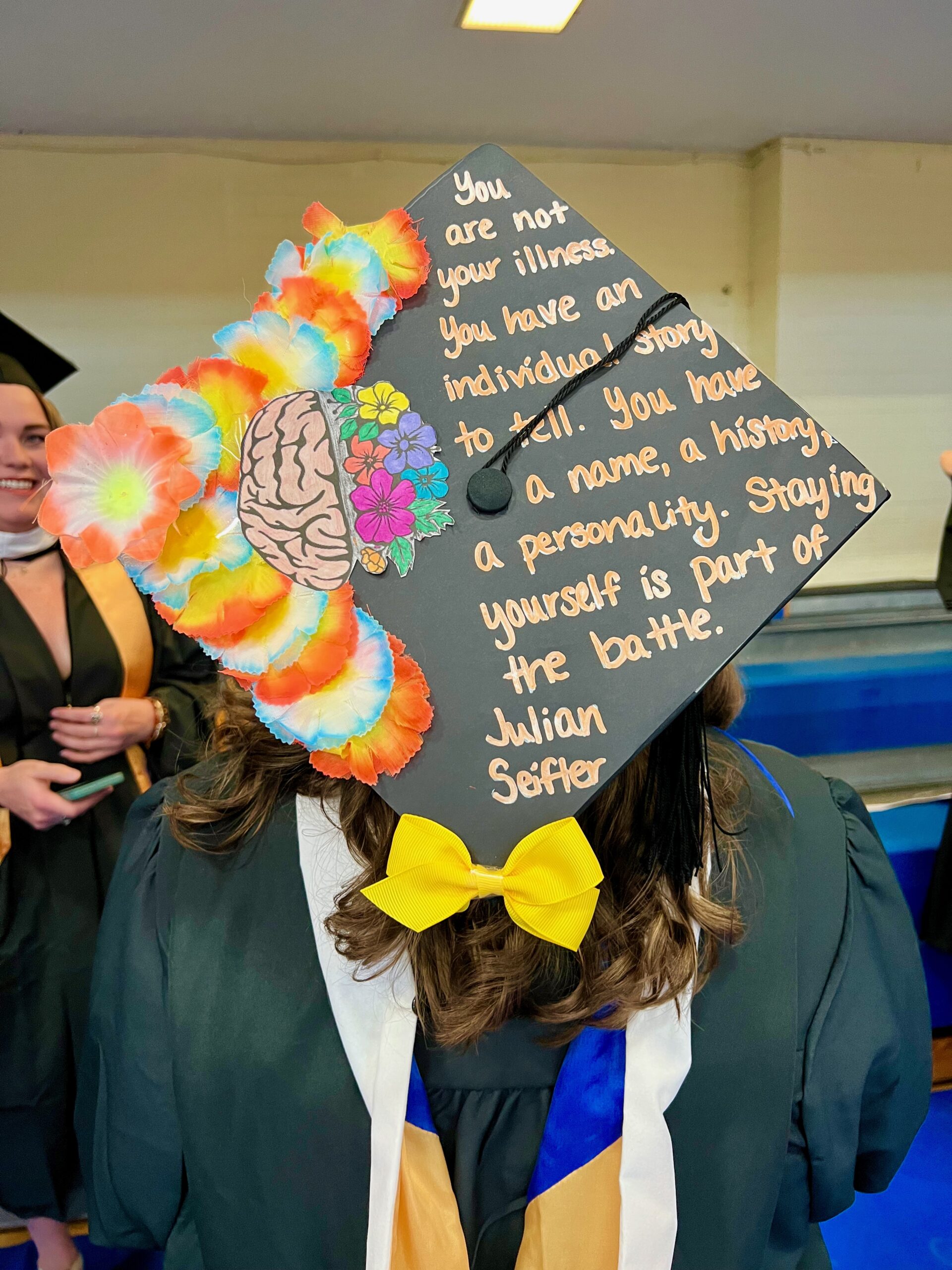 Decorated mortarboard reading "You are not your illness. You have and individual sotry to tell. You have a name, a history, a personality. Staying yourself is part of the battle. -Julian Seifler"