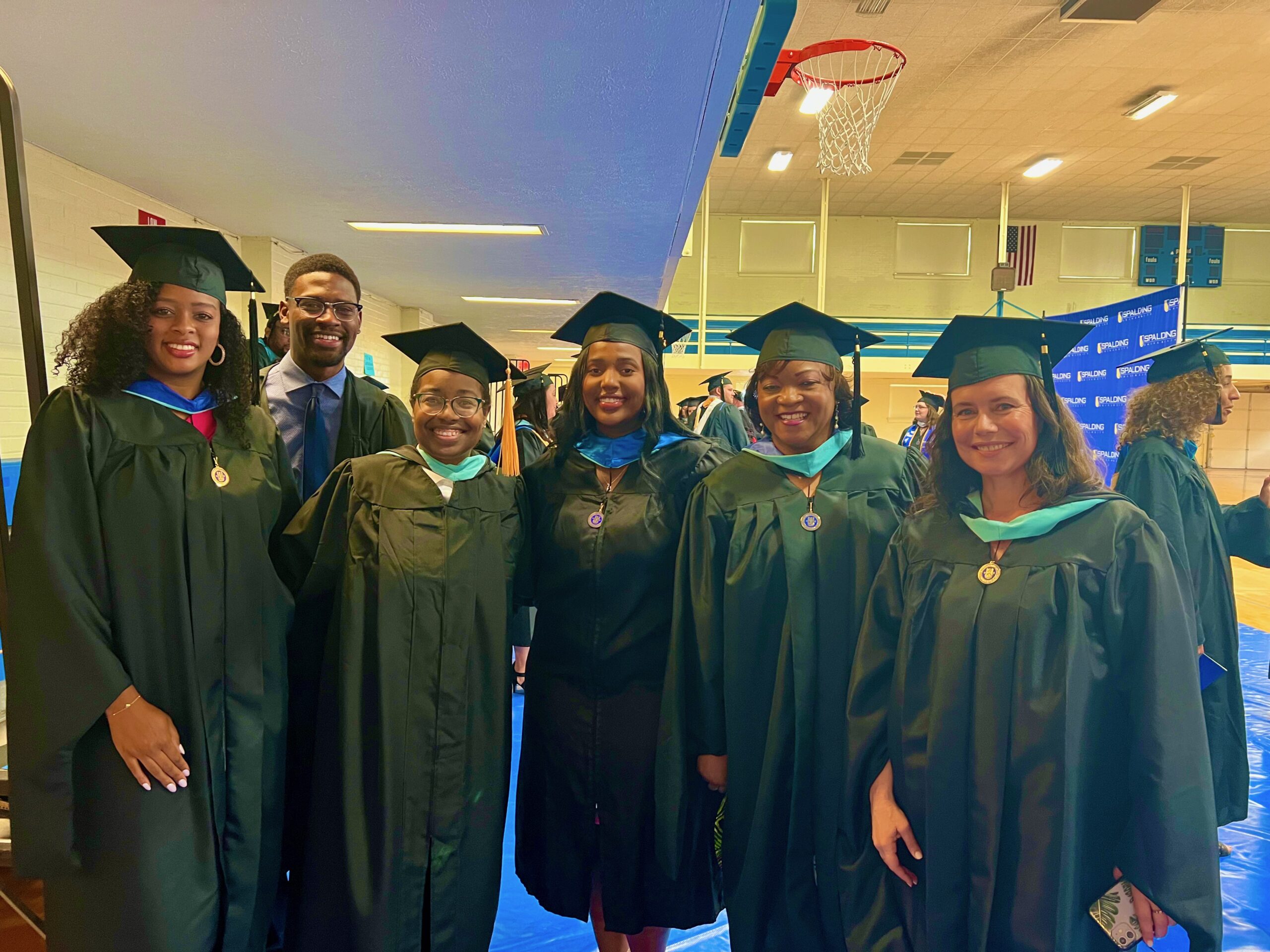 Group of Spalding master's graduates posing for picture in Columbia Gym