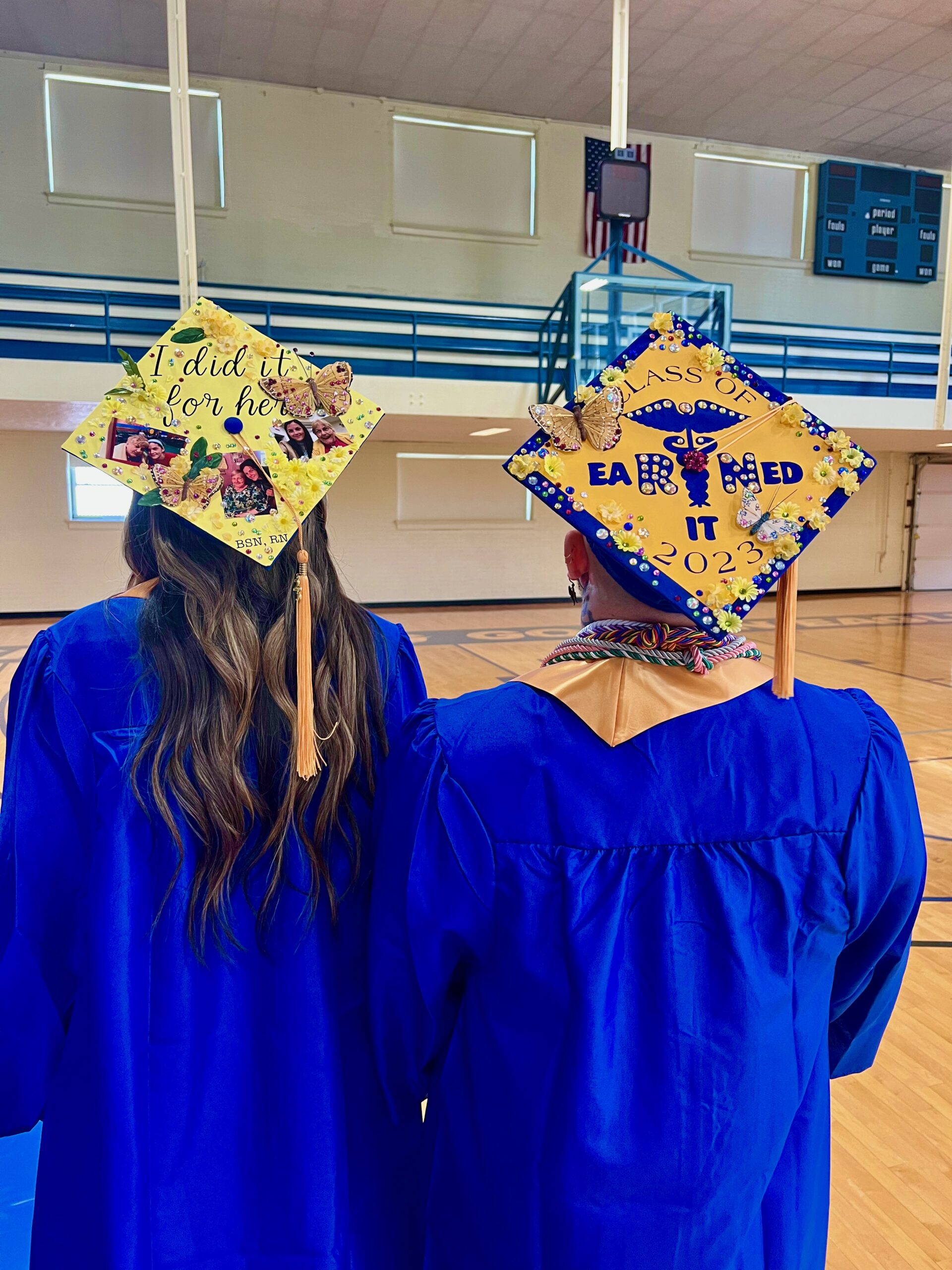Two Spalding bachelor's graduates with decorated mortarboards