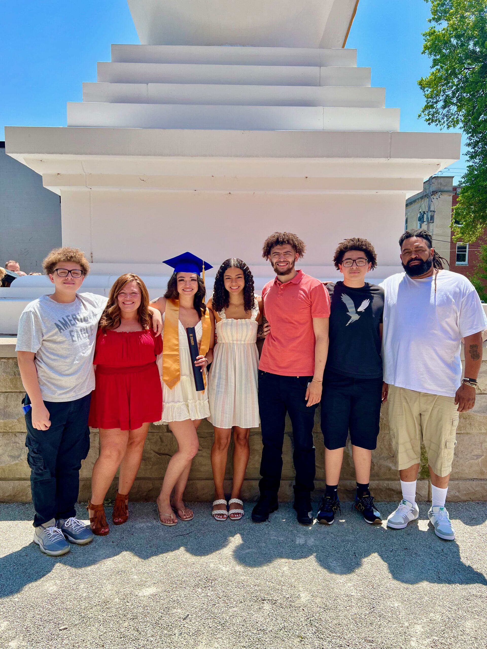 Spalding bachelor's graduate posing with family for photo outside