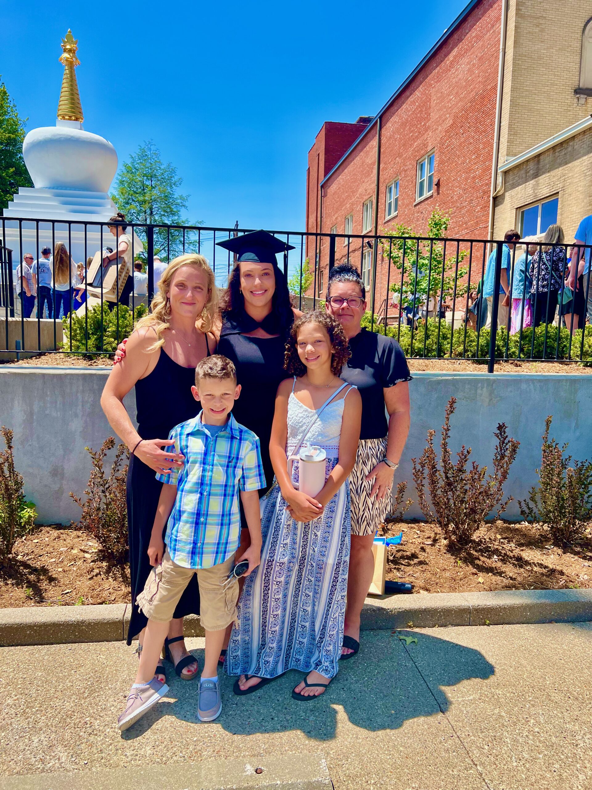 Spalding master's graduate posing with family for photo outside