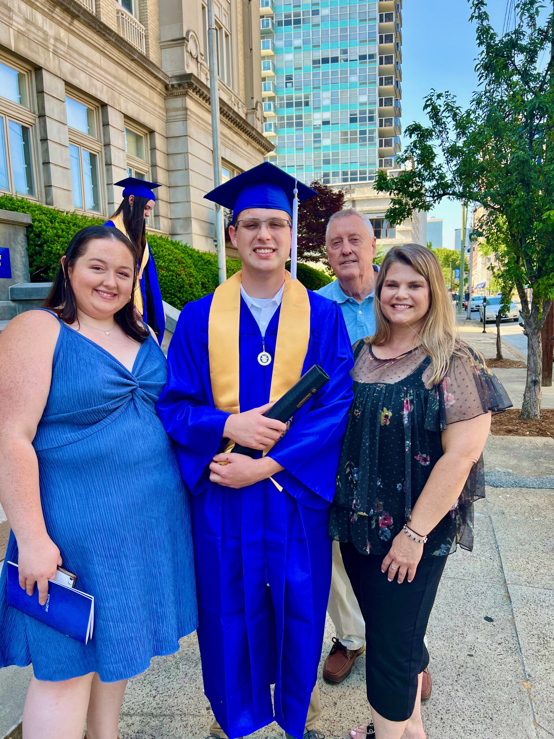 Spalding bachelor's graduate posing with family member for photo outside