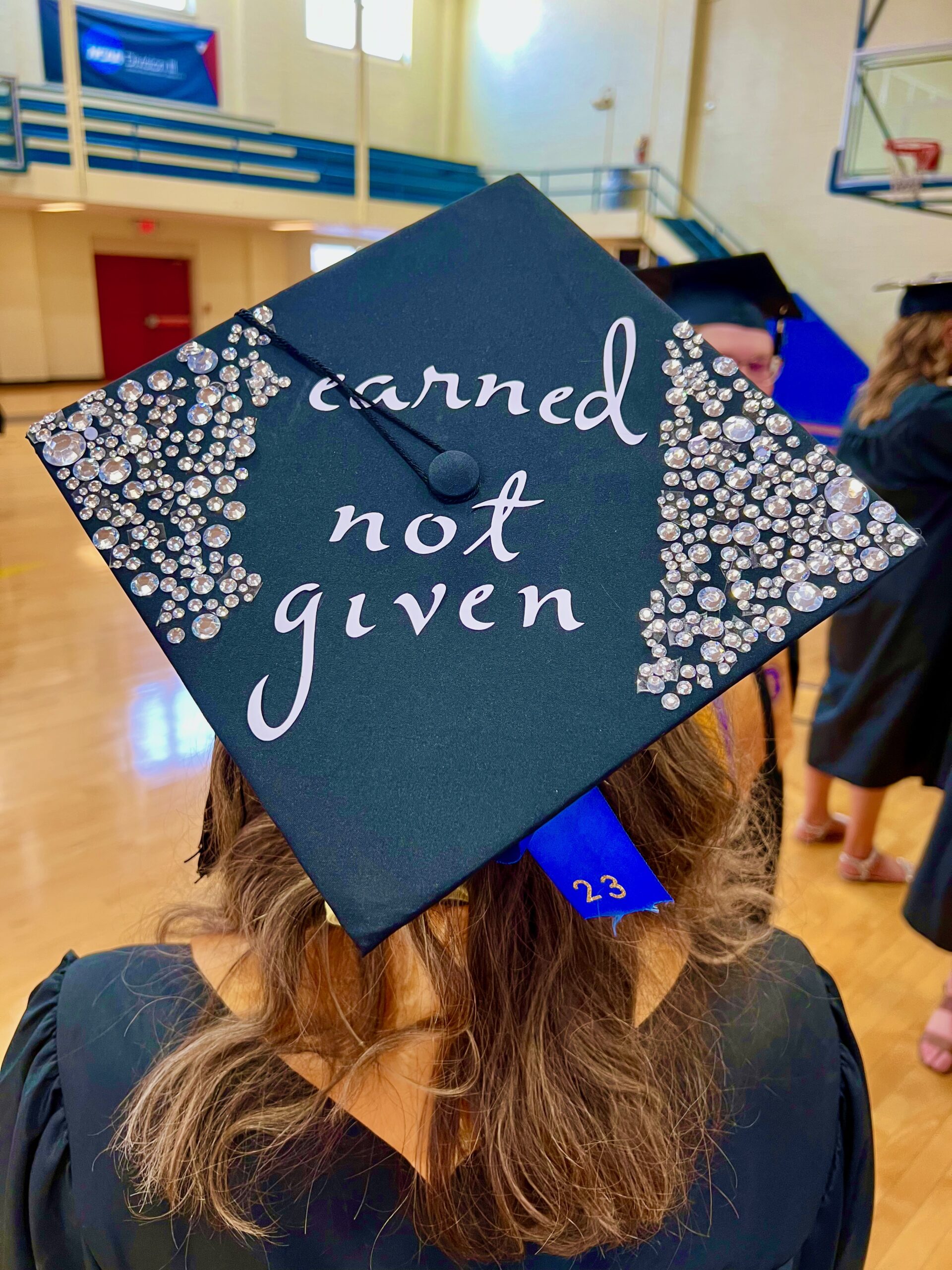 Decorated mortarboard reading "Earned not given"