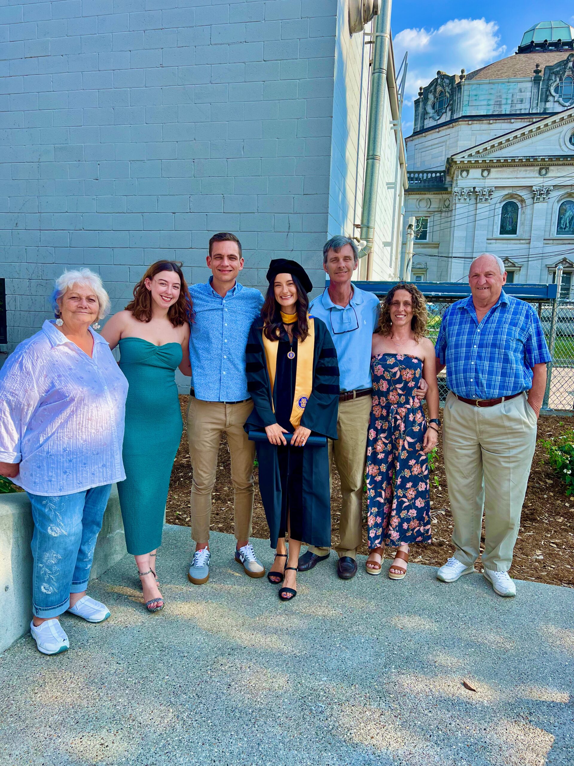 Spalding doctoral graduate posing with family for photo outside
