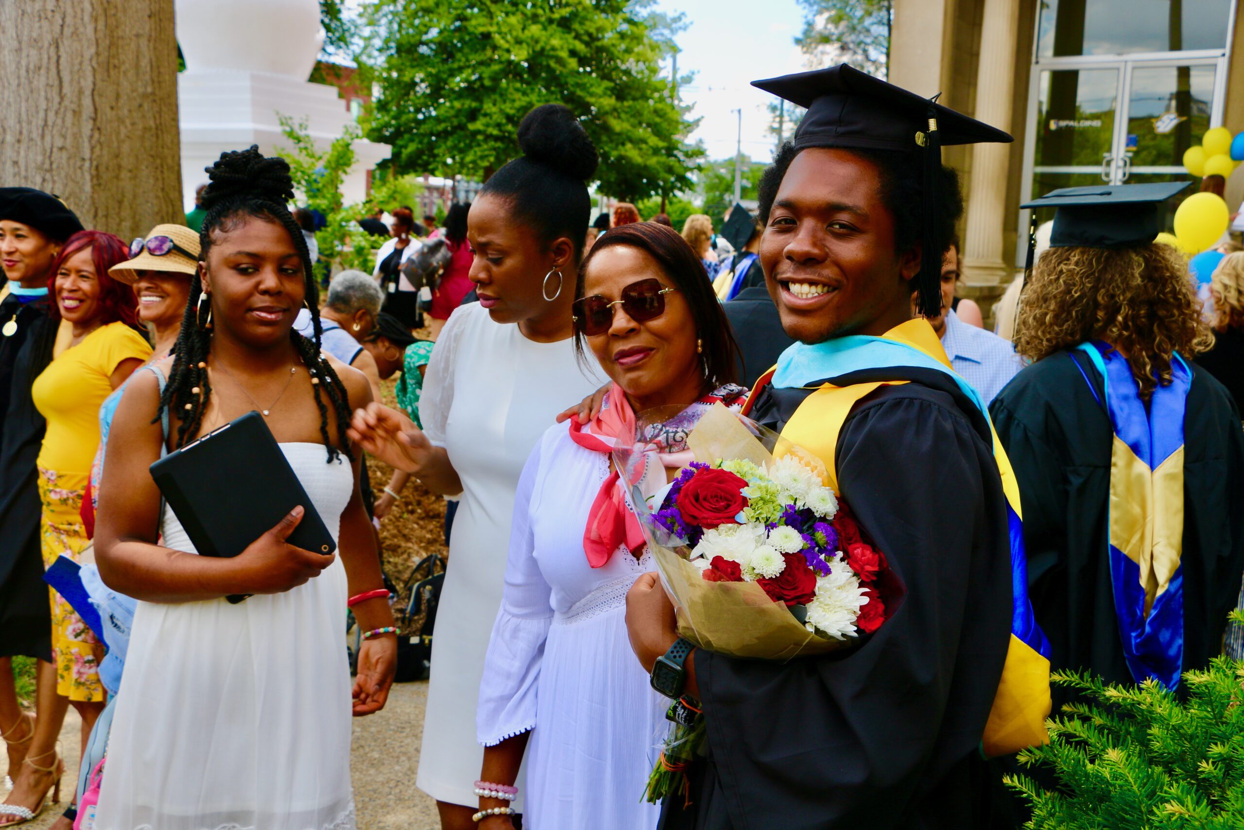 Spalding master's graduate posing with family members outside