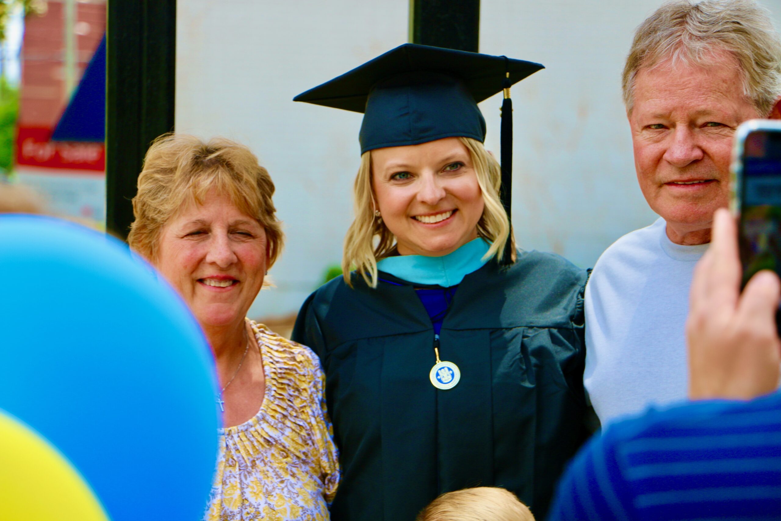 Spalding master's graduate posing with parents