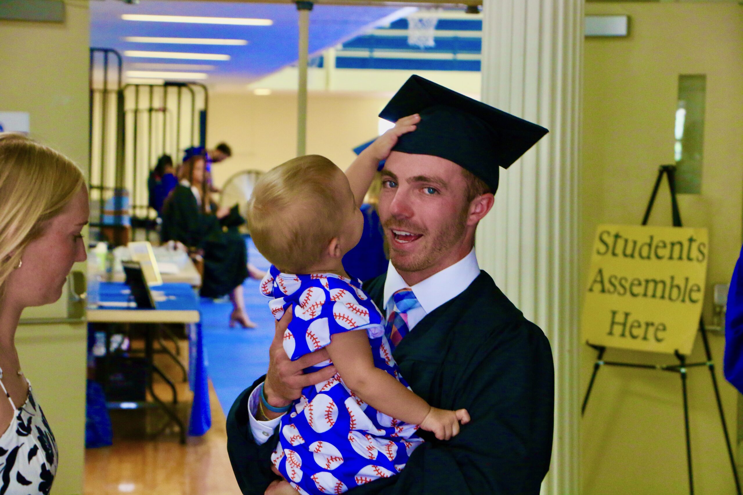 Spalding master's graduate holding his young child