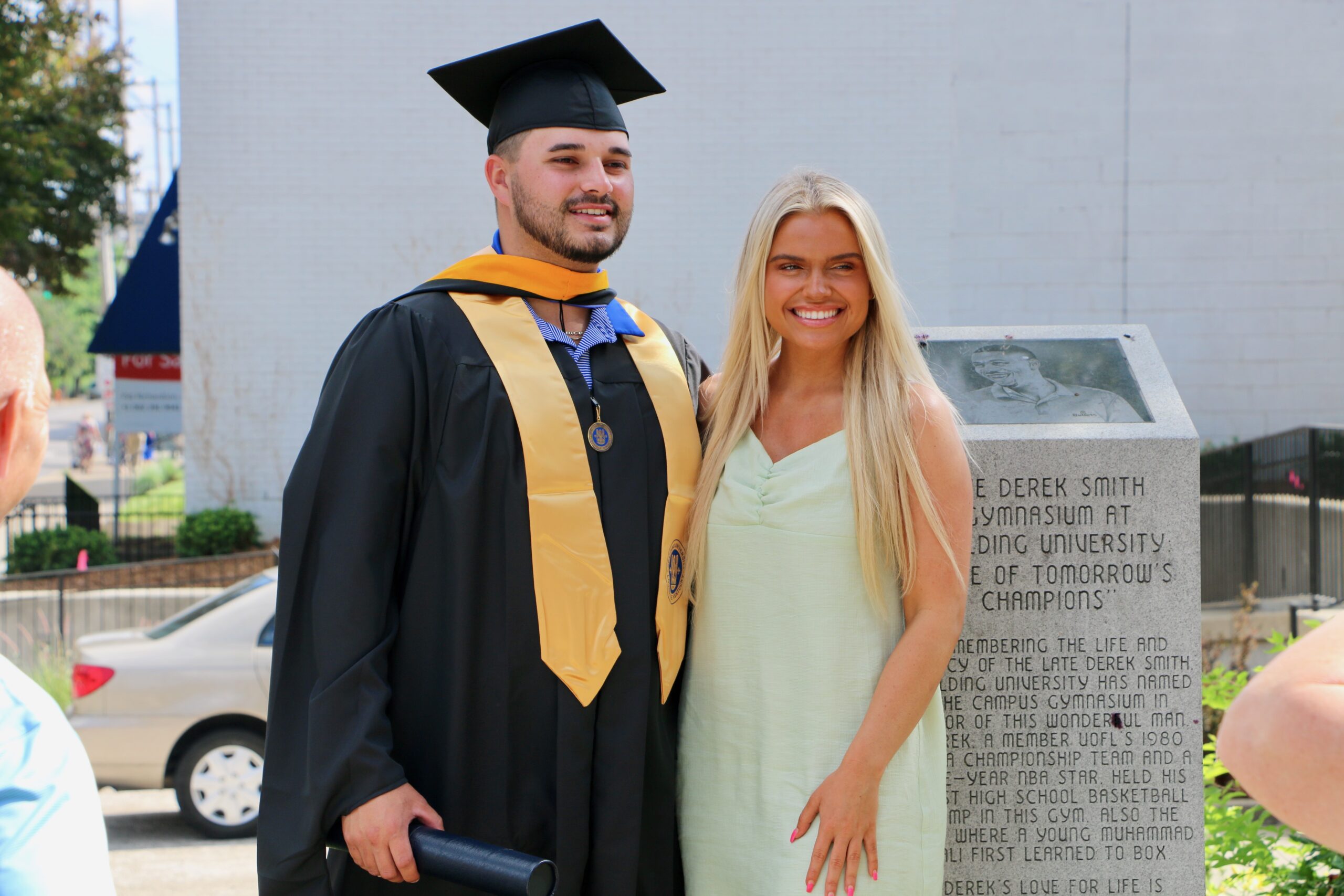 Spalding master's graduate posing with significant other outside