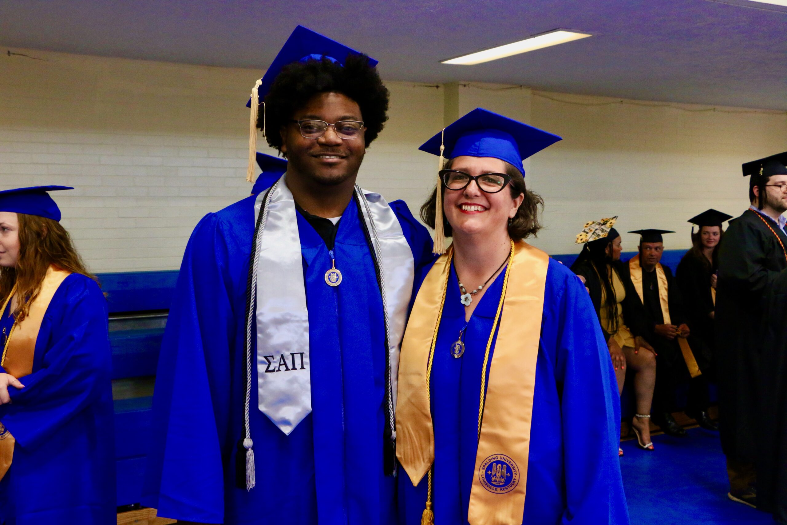 Two Spalding bachelor's graduates posing for photo in Columbia Gym