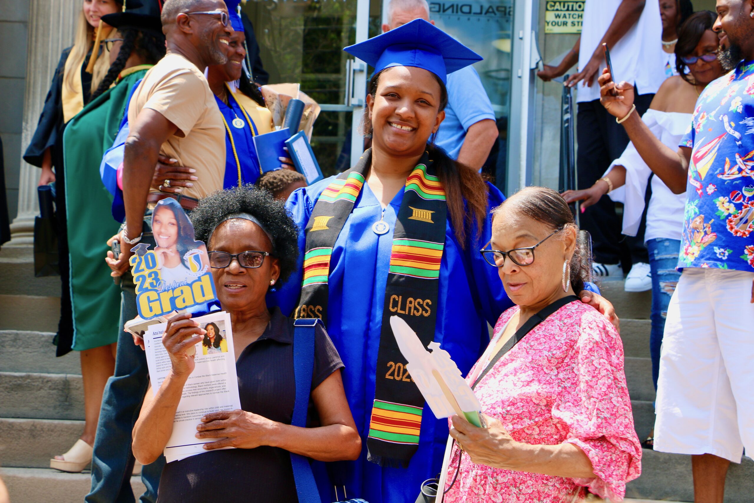 Spalding bachelor's graduate standing with family on steps of Columbia Gym