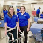 Occupational therapy doctorate students practicing in sim lab with walker.