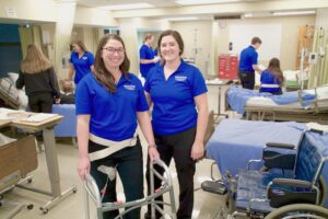 Occupational therapy doctorate students practicing in sim lab with walker.