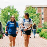 Three Spalding students walking to class through ELC courtyard