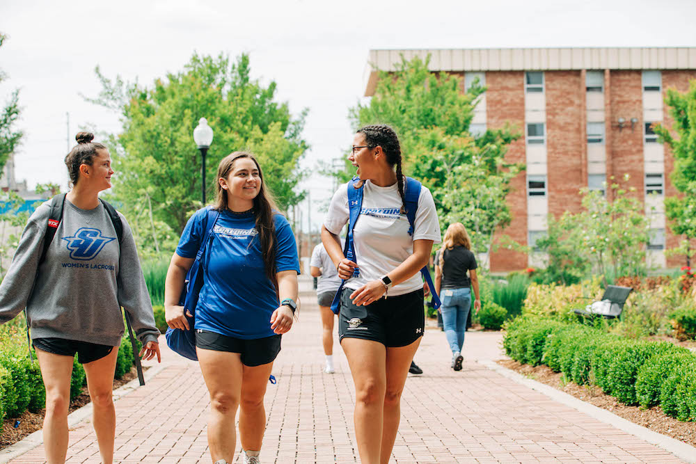Three Spalding students walking to class through ELC courtyard