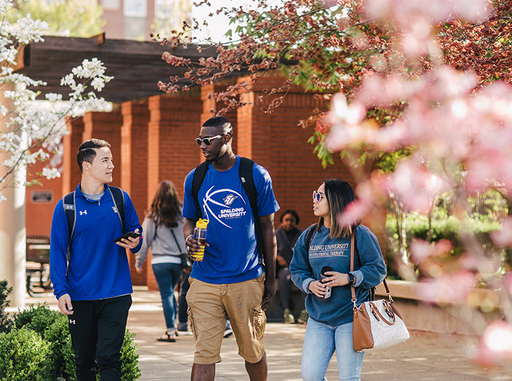 Three students walking outside to class.