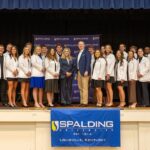 Doctor of Physical Therapy students on stage with President Anne Kenworthy, and DPT faculty.