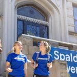 three students laughing outside Spalding University building